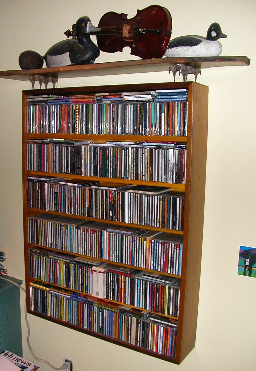 cd cabinet with to shelf supported by Henry James fork crowns. These 